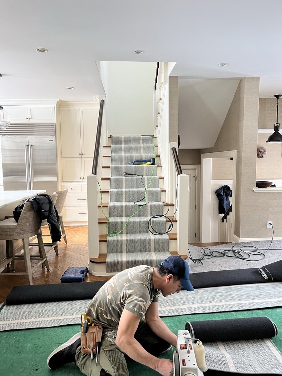 Stair runner installation during an active residential project by Twig and Trove Interiors